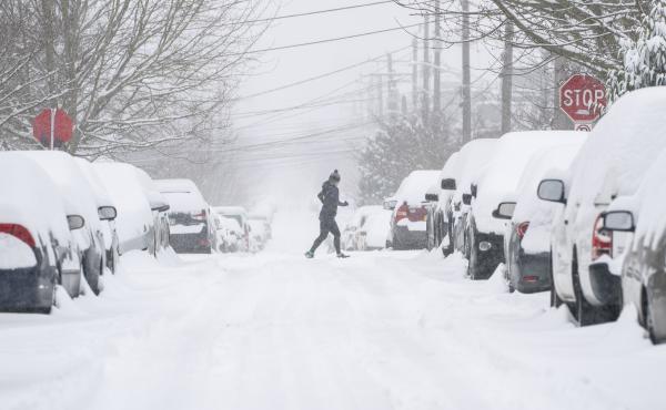 A jogger makes their way across a snowy street on Saturday in Seattle. A large winter storm dropped heavy snow across the region. A jogger makes their way across a snowy street on Saturday in Seattle. A large winter storm dropped heavy snow across the region.