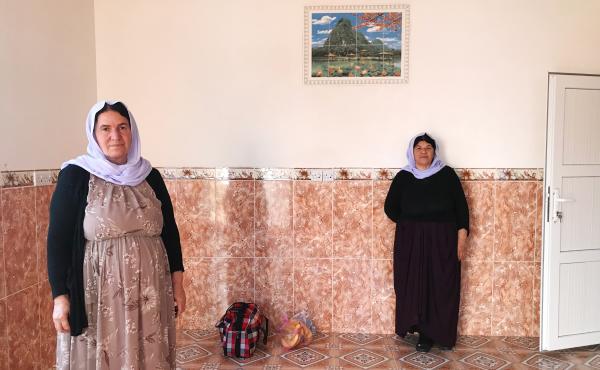 Nofa Khudeda (left) and a neighbor in the village of Tel Qasab on the day Khudeda and her husband returned after six years in a camp for displaced Yazidis. Khudeda and her husband, Ali Edo, repaired and renovated the house, which had been looted by ISIS f Nofa Khudeda (left) and a neighbor in the village of Tel Qasab on the day Khudeda and her husband returned after six years in a camp for displaced Yazidis. Khudeda and her husband, Ali Edo, repaired and renovated the house, which had been looted by ISIS f