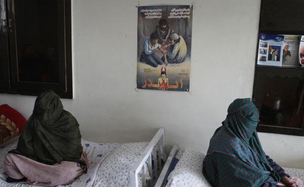 Two women sit, with their faces covered, at a drug treatment center in Kabul, Afghanistan. Two women sit, with their faces covered, at a drug treatment center in Kabul, Afghanistan.