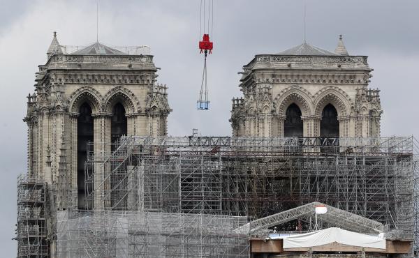 A box hangs from a crane at Notre Dame cathedral on Monday. Officials said they hope to hold Mass in the cathedral by 2024, when the city is set to host the Olympic games. A box hangs from a crane at Notre Dame cathedral on Monday. Officials said they hope to hold Mass in the cathedral by 2024, when the city is set to host the Olympic games.