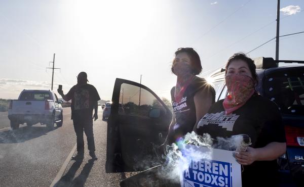 Demonstrators stand along the road in front of the La Palma Correctional Center in Eloy on April 10, 2020. The event was one of several car rallies calling for the release of immigrants detained at the ICE facility during COVID-19. Demonstrators stand along the road in front of the La Palma Correctional Center in Eloy on April 10, 2020. The event was one of several car rallies calling for the release of immigrants detained at the ICE facility during COVID-19.