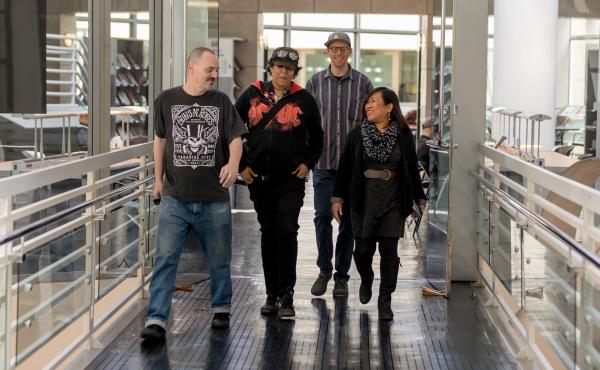 Leah Esguerra (right), who is credited with being the first social worker installed directly at a public library, strolls through the fifth floor of the San Francisco Public Library's main branch, joined by the library's health and safety associates (from Leah Esguerra (right), who is credited with being the first social worker installed directly at a public library, strolls through the fifth floor of the San Francisco Public Library's main branch, joined by the library's health and safety associates (from