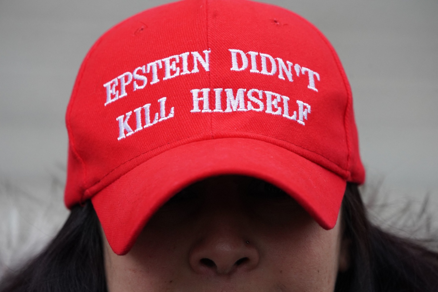 A protester outside of the Maxwell trial wearing a hat claiming that Epstein's death was not a suicide.