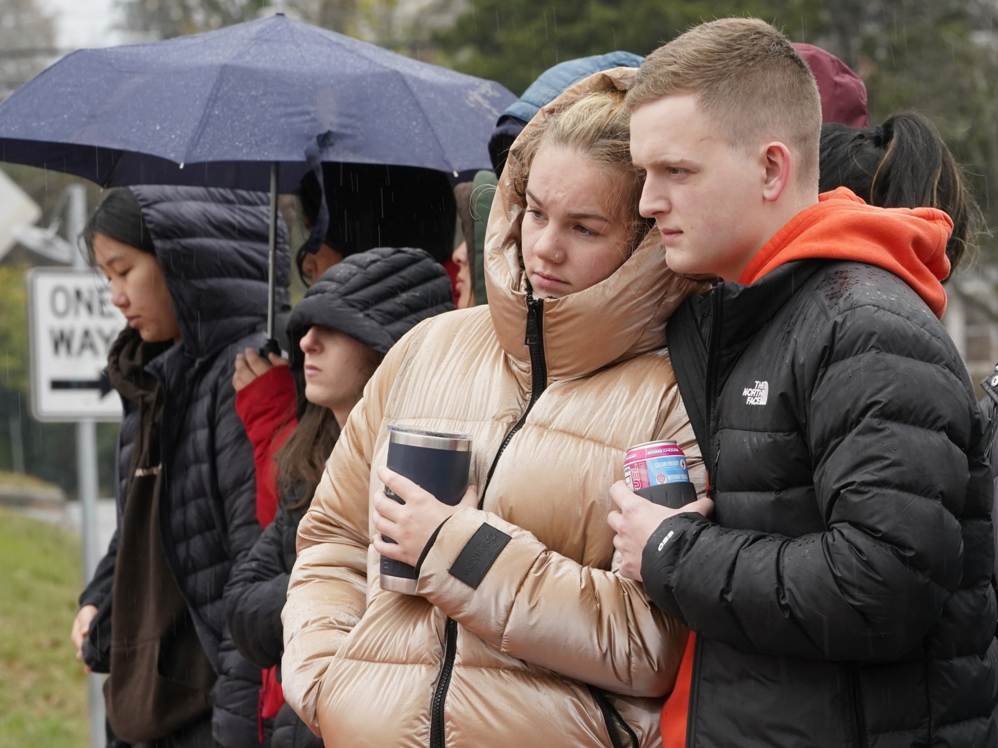 Mourners look over flowers that line a bridge near the scene of a shooting on the grounds of the University of Virginia Tuesday Nov. 15, 2022, in Charlottesville. Va.